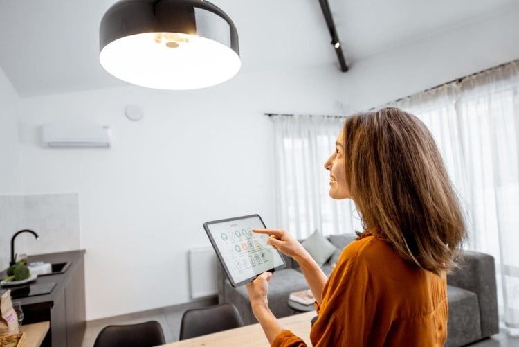 Young woman controlling home light with a digital tablet